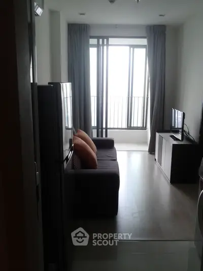 Modern living room with large windows and stylish furniture in a bright apartment.