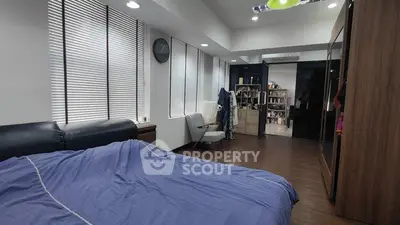 Spacious bedroom with modern decor and ample natural light from large windows.