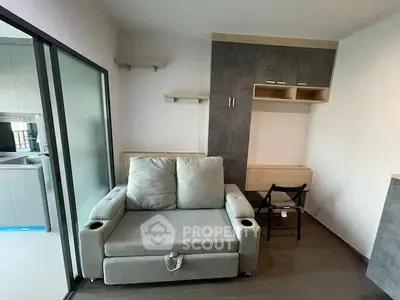 Modern living room with stylish sofa and sleek storage solutions in a compact apartment.