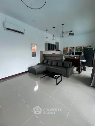 Modern living room with sleek furniture and open kitchen layout, perfect for contemporary living.