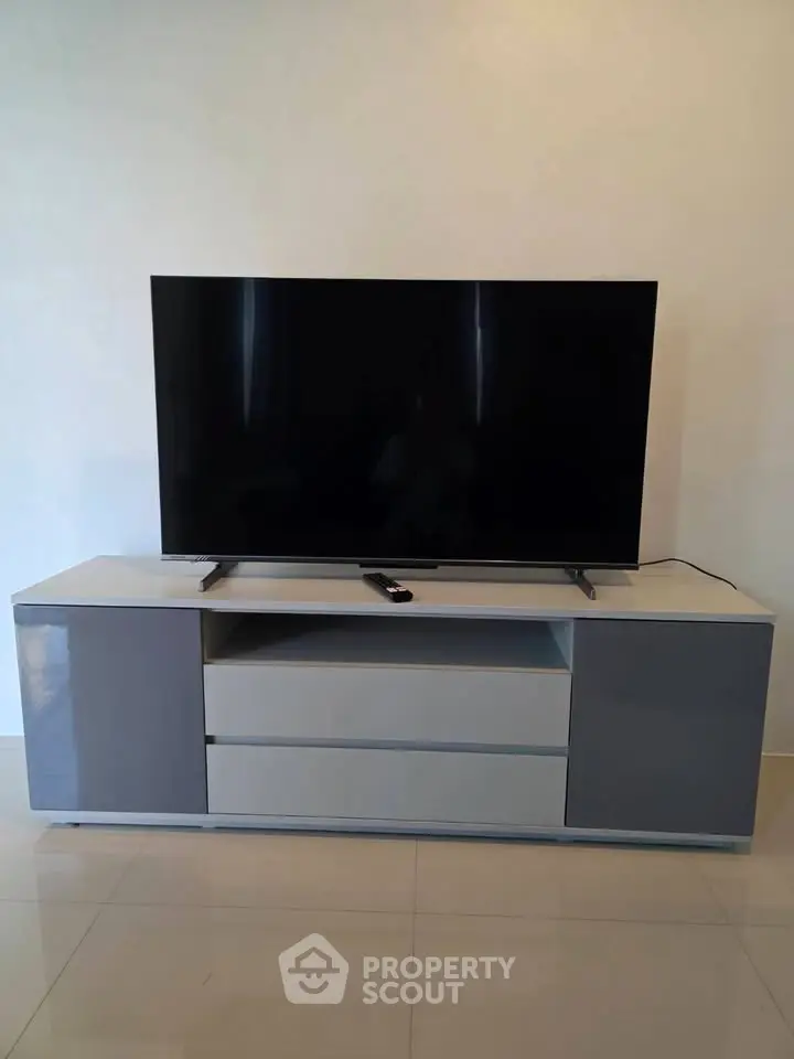 Modern living room setup with sleek TV stand and large flat-screen TV, perfect for entertainment.