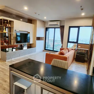 Spacious modern living room with large windows and stylish furniture, offering a panoramic city view.