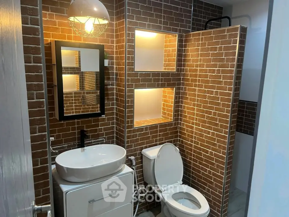 Modern bathroom with brick accent wall and stylish lighting