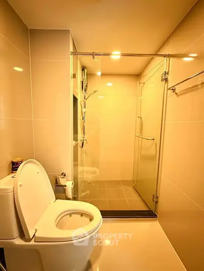 Modern bathroom with glass shower and sleek fixtures in a contemporary apartment.