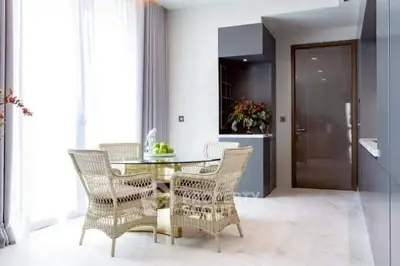 Elegant dining area with wicker chairs and glass table in modern apartment