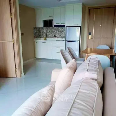 Modern open-plan living room with compact kitchen and cozy dining area.