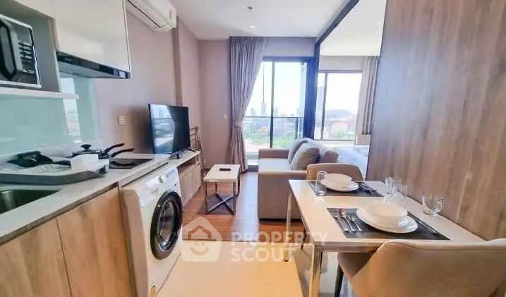 Modern studio apartment with open kitchen, cozy living area, and city view.