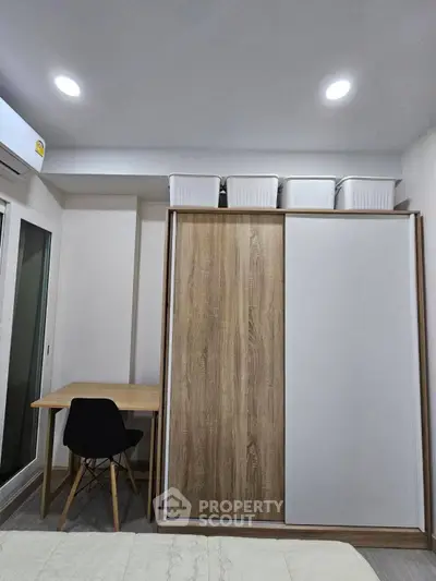 Modern bedroom with sliding wardrobe and study desk, ideal for compact living spaces.