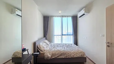 Modern bedroom with large window and air conditioning in stylish apartment.
