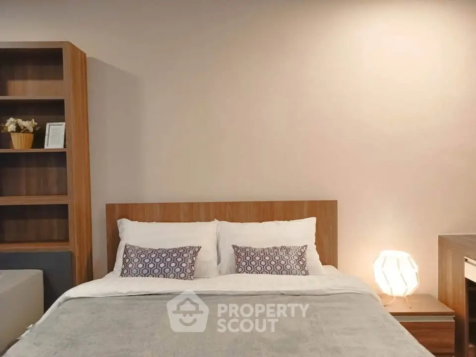 Cozy bedroom with modern wooden furniture and soft lighting, perfect for relaxation.