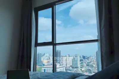 Stunning cityscape view from a cozy bedroom window, perfect for urban living.