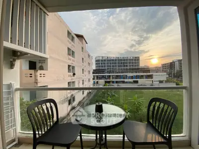 Charming balcony view with sunset over modern apartment complex, perfect for relaxation.