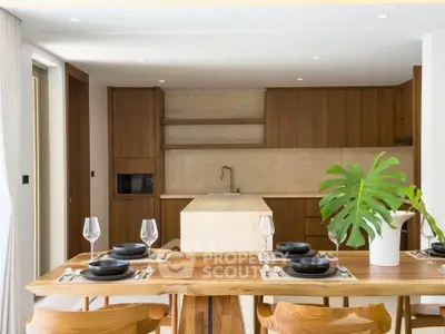 Modern kitchen with wooden cabinets and elegant dining area featuring a stylish table and chairs.