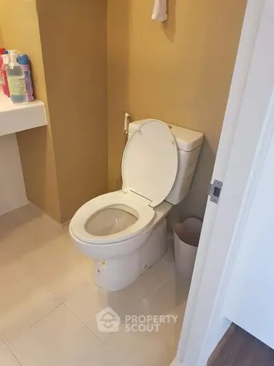 Modern bathroom with sleek toilet and beige walls, perfect for a cozy home.