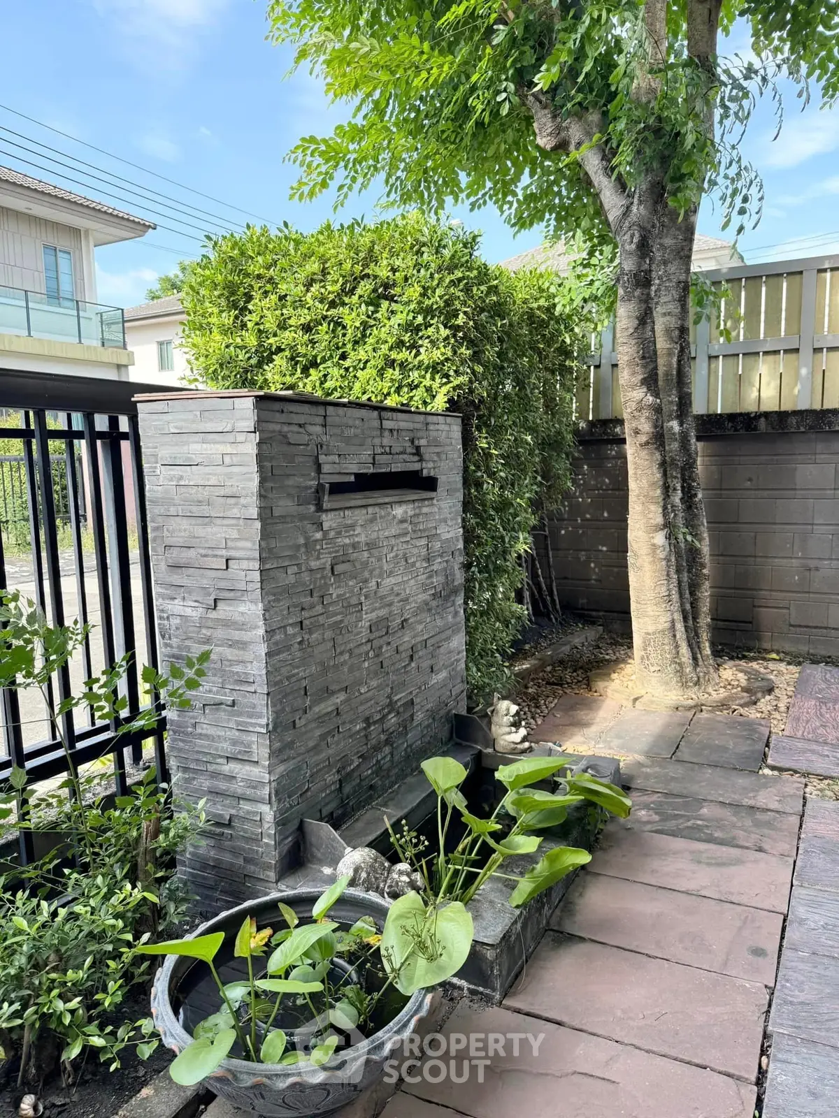 Charming garden corner with stone water feature and lush greenery, perfect for relaxation and outdoor enjoyment.