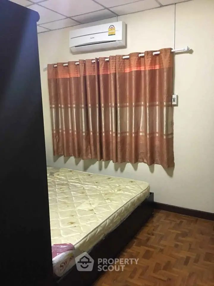 Cozy bedroom with air conditioning and wooden flooring, ideal for comfort and relaxation.