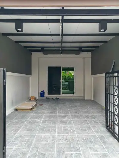 Spacious modern garage with tiled flooring and open layout, perfect for parking or storage.