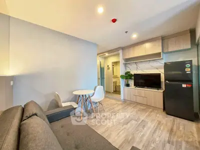 Modern living room with stylish furniture and open layout, featuring a cozy sofa and sleek appliances.