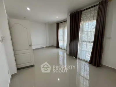 Spacious empty room with large windows and elegant curtains