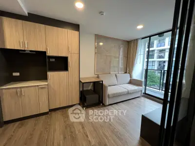 Modern living room with wooden flooring, cozy sofa, and balcony view in a stylish apartment.