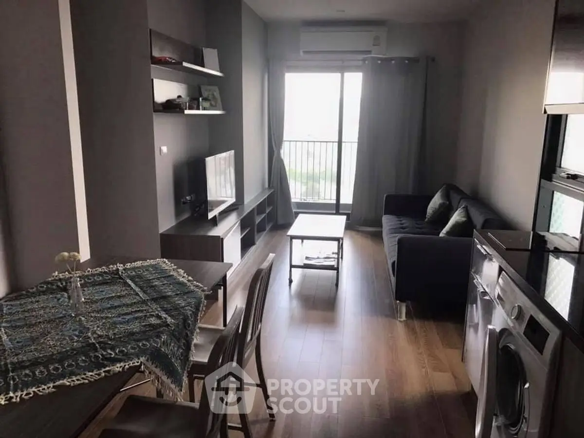 Modern living room with balcony, washing machine, and stylish decor.
