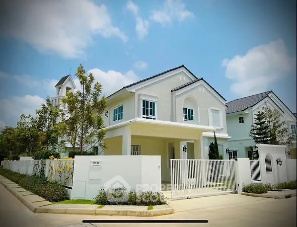 Charming suburban house with white facade and spacious driveway under clear blue sky.