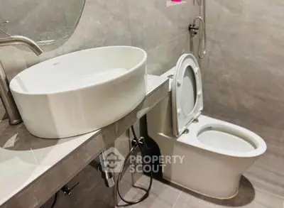 Modern bathroom with sleek fixtures and elegant design, featuring a stylish sink and toilet.
