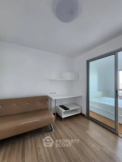 Modern apartment interior with sleek design, featuring a cozy living area and a glimpse into a bright bedroom.
