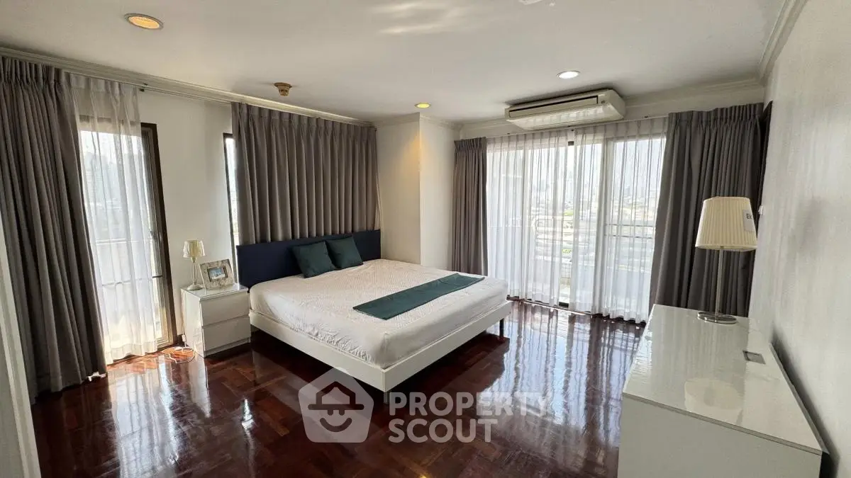 Spacious bedroom with large windows and elegant decor in modern apartment