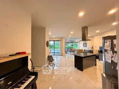 Spacious open-plan living area with modern kitchen and elegant marble flooring.