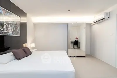 Modern minimalist bedroom with sleek design and mirrored wardrobe