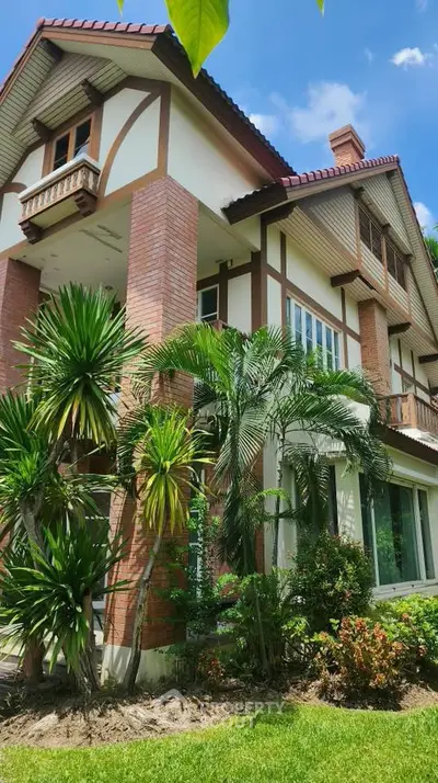 Charming two-story house with lush garden and classic architectural design, perfect for family living.