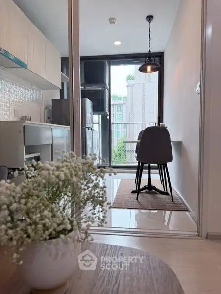 Modern kitchen with sleek design and dining area overlooking city view.