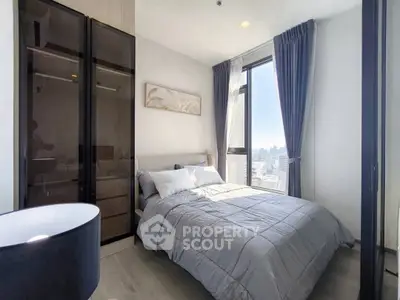 Modern bedroom with city view, featuring elegant decor and ample natural light.