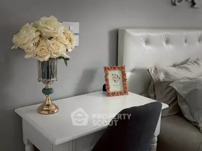 Elegant bedroom nightstand with floral decor and plush headboard