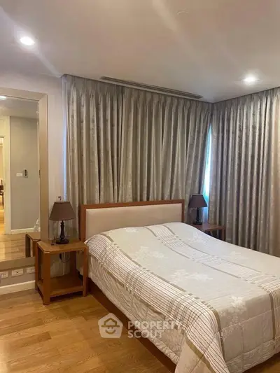 Elegant bedroom with cozy lighting and stylish decor, featuring a comfortable bed and wooden flooring.