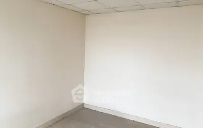 Spacious empty room with tiled floor and white walls, ideal for customization.