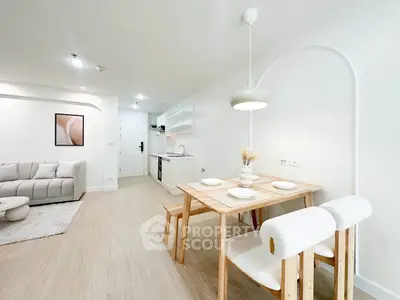 Modern open-plan living room and kitchen with stylish dining area and cozy sofa.