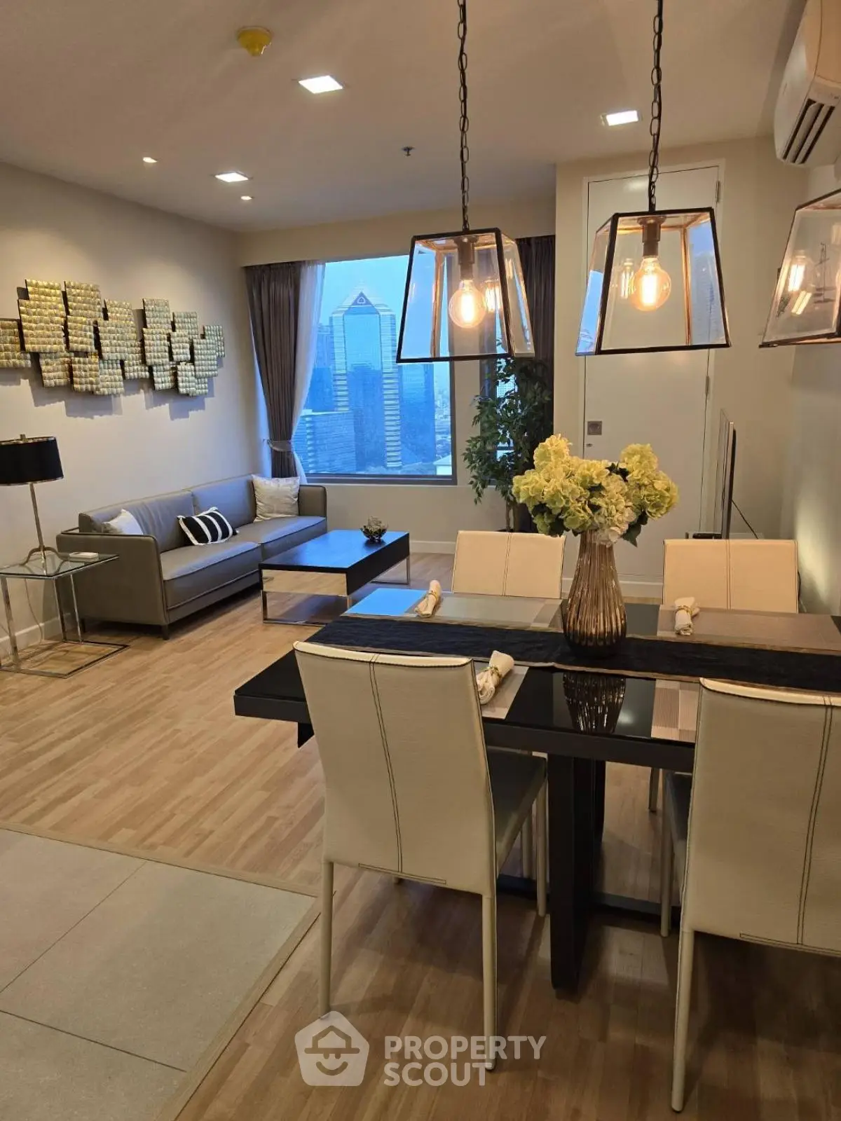 Modern living room with city view, stylish decor, and elegant dining area in a high-rise apartment.