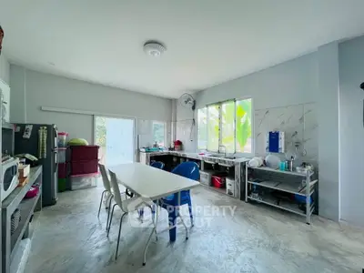 Spacious kitchen with open layout and natural light, featuring modern appliances and ample dining space.