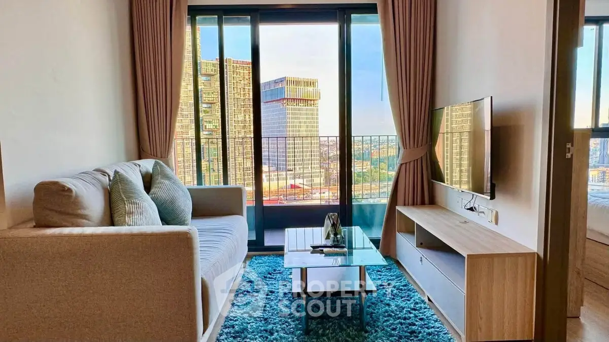 Modern living room with city view, stylish sofa, and sleek TV setup in high-rise apartment.