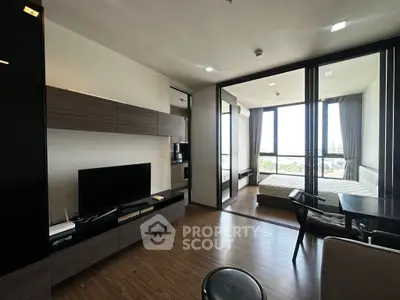 Modern open-plan living room with sleek furnishings and large windows offering a stunning view.