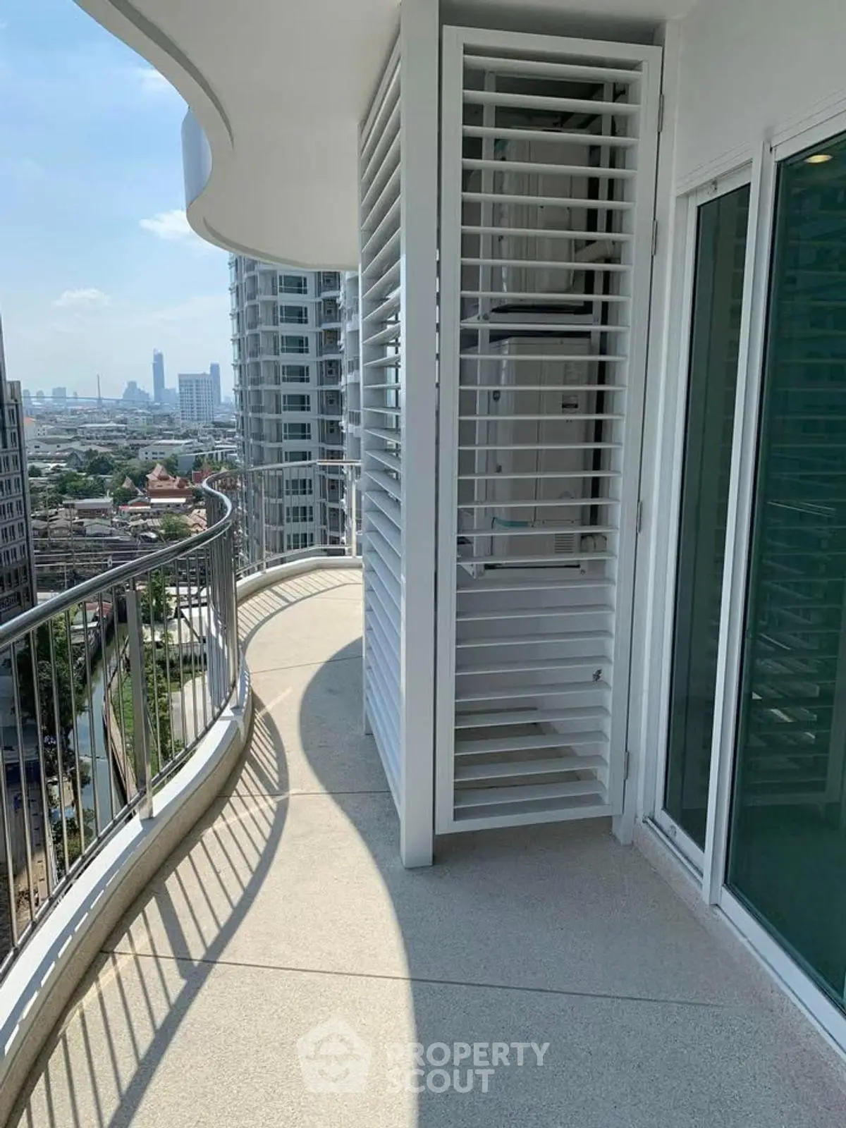 Spacious curved balcony with city view in modern high-rise building