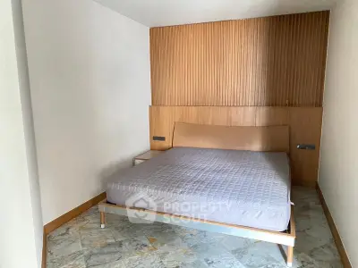 Modern minimalist bedroom with wooden accents and marble flooring