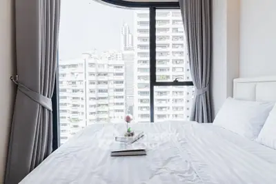 Bright bedroom with city view and elegant curtains in modern apartment
