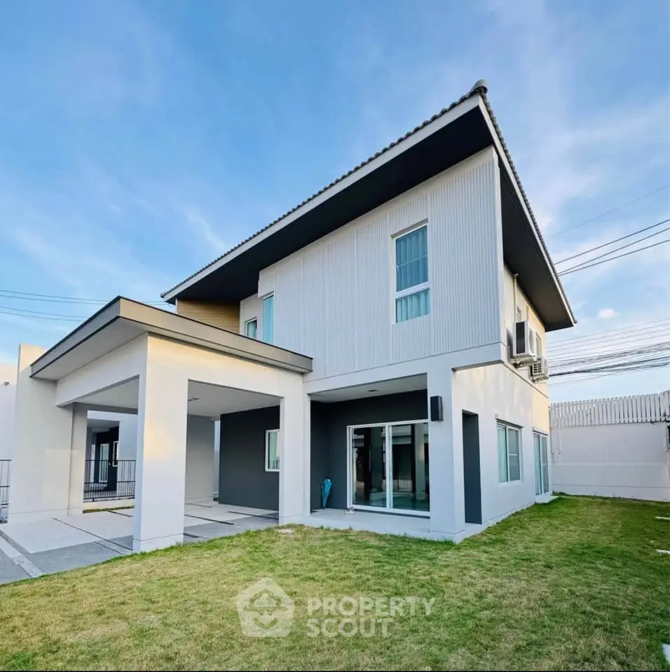 Modern two-story house with sleek design and spacious lawn, perfect for family living.