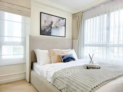 Luxurious bedroom with elegant decor and large windows for natural light.