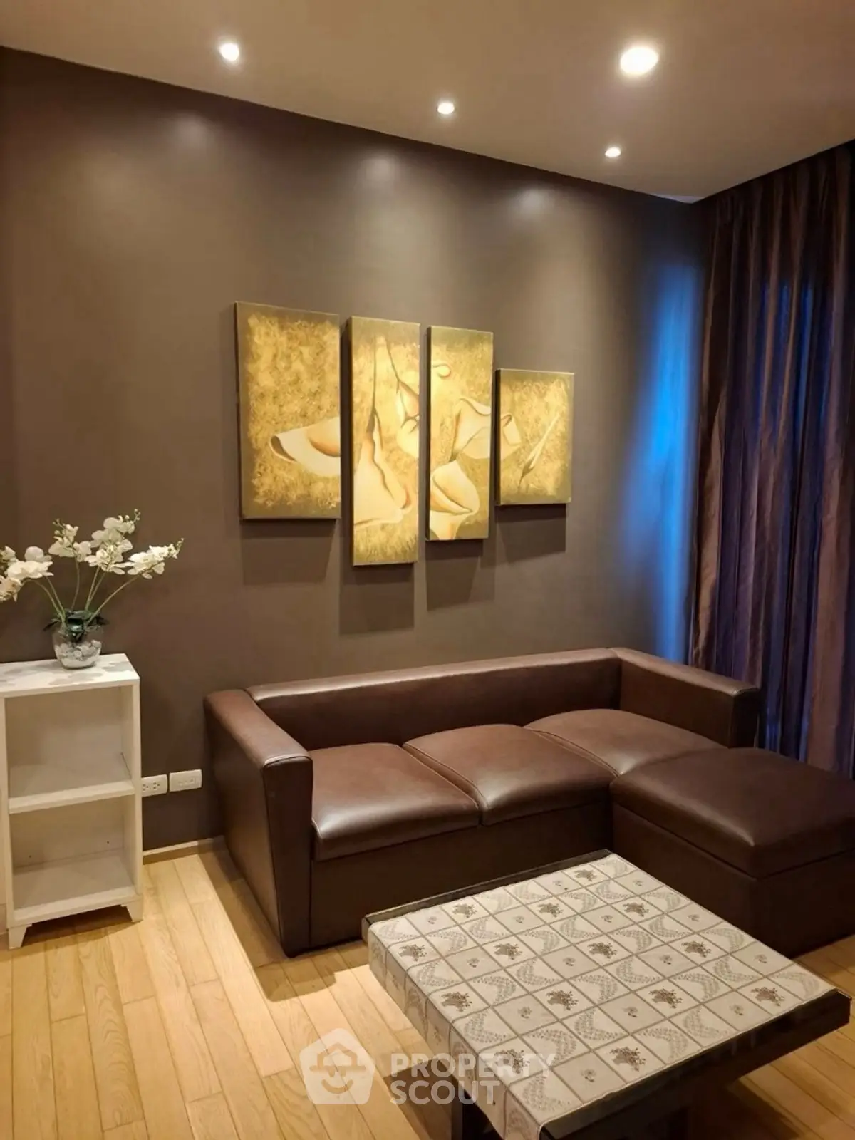 Elegant living room with brown leather sofa and modern art decor