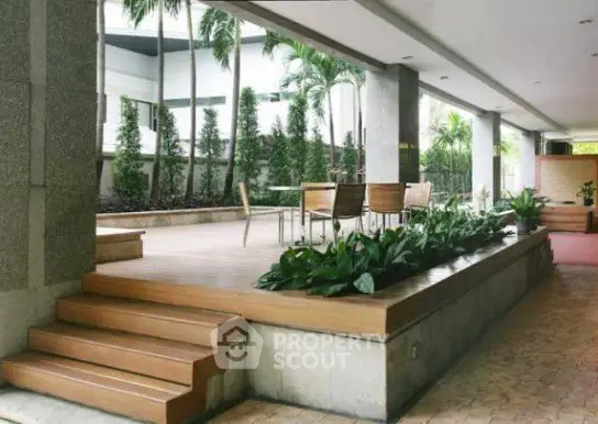 Elegant outdoor terrace with lush greenery and modern seating area in luxury property.