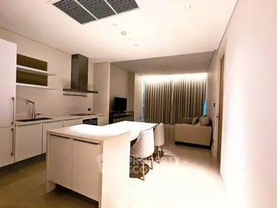 Modern open-layout kitchen and living area with sleek design and ambient lighting.
